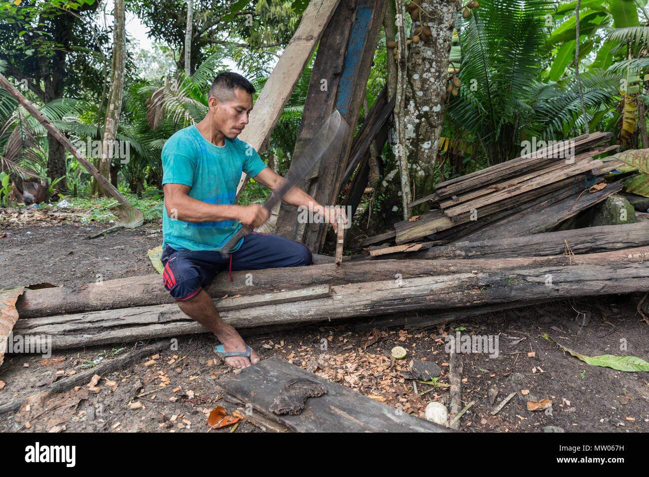 L'uomo utilizzando machete per lavorare legno, San Francisco Village, Loreto, Perù Foto Stock