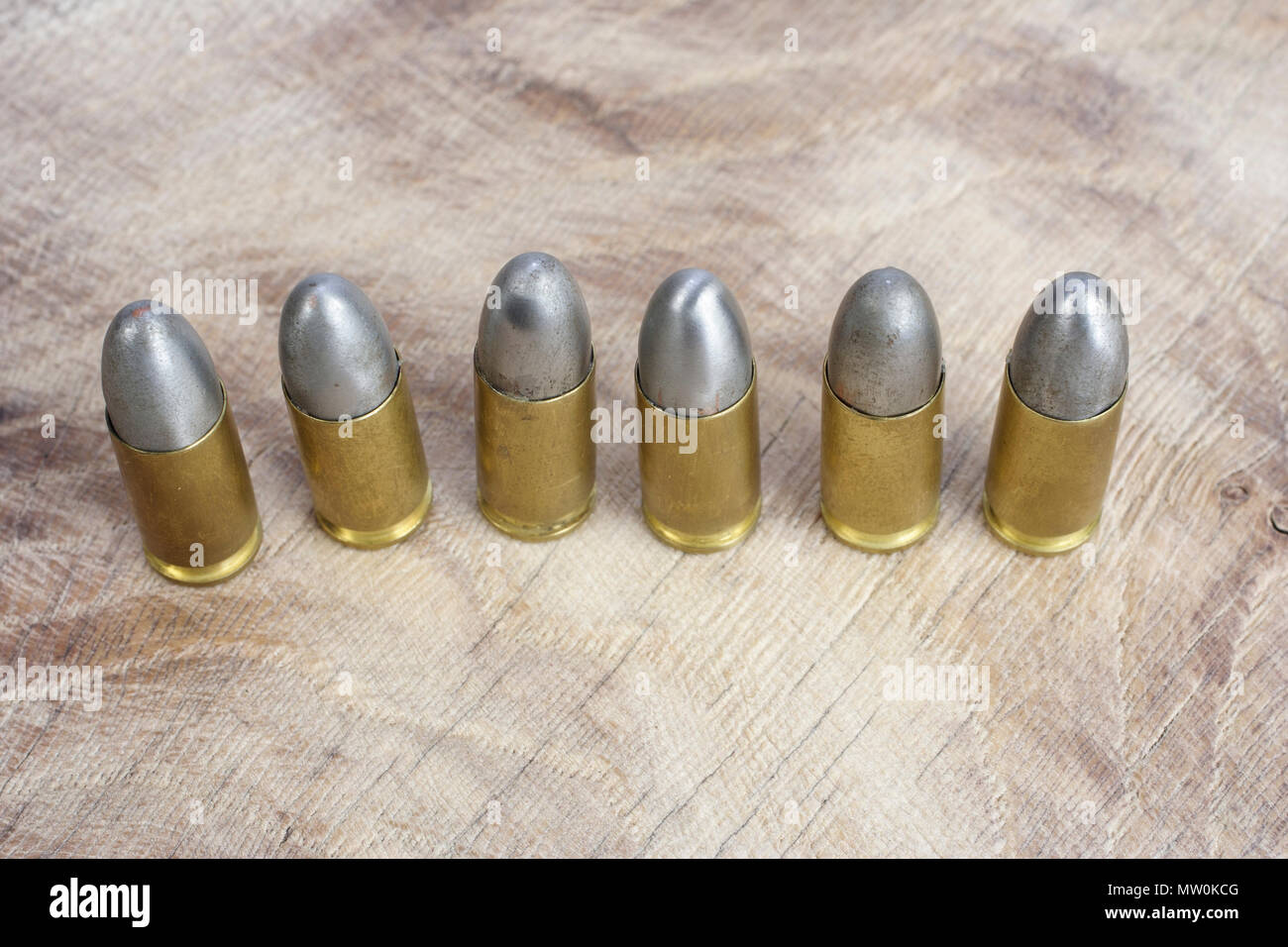 Il 9mm cartucce calibro su sfondo di legno Foto Stock