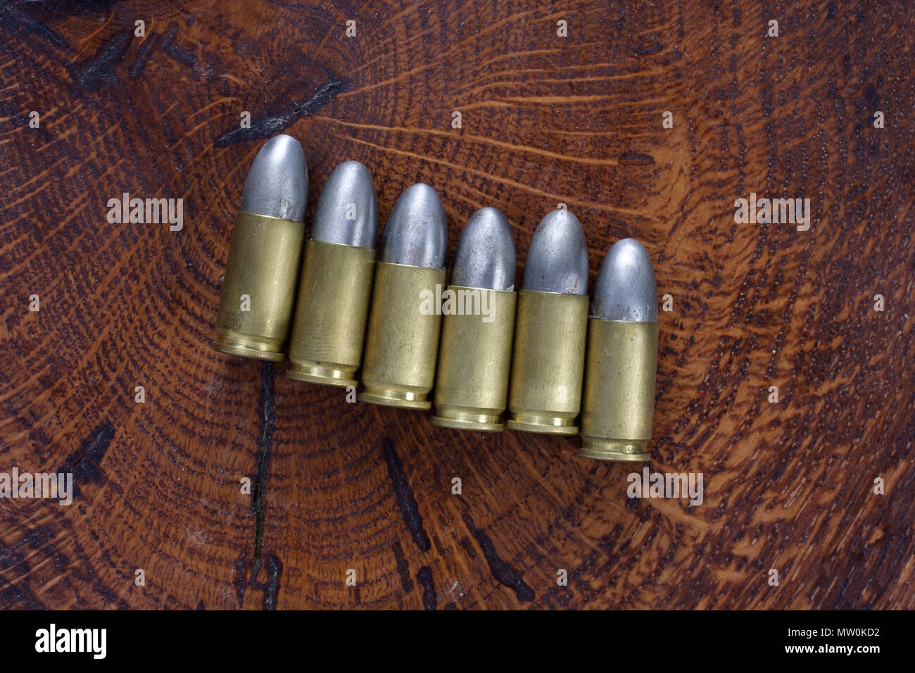 Il 9mm cartucce calibro su sfondo di legno Foto Stock