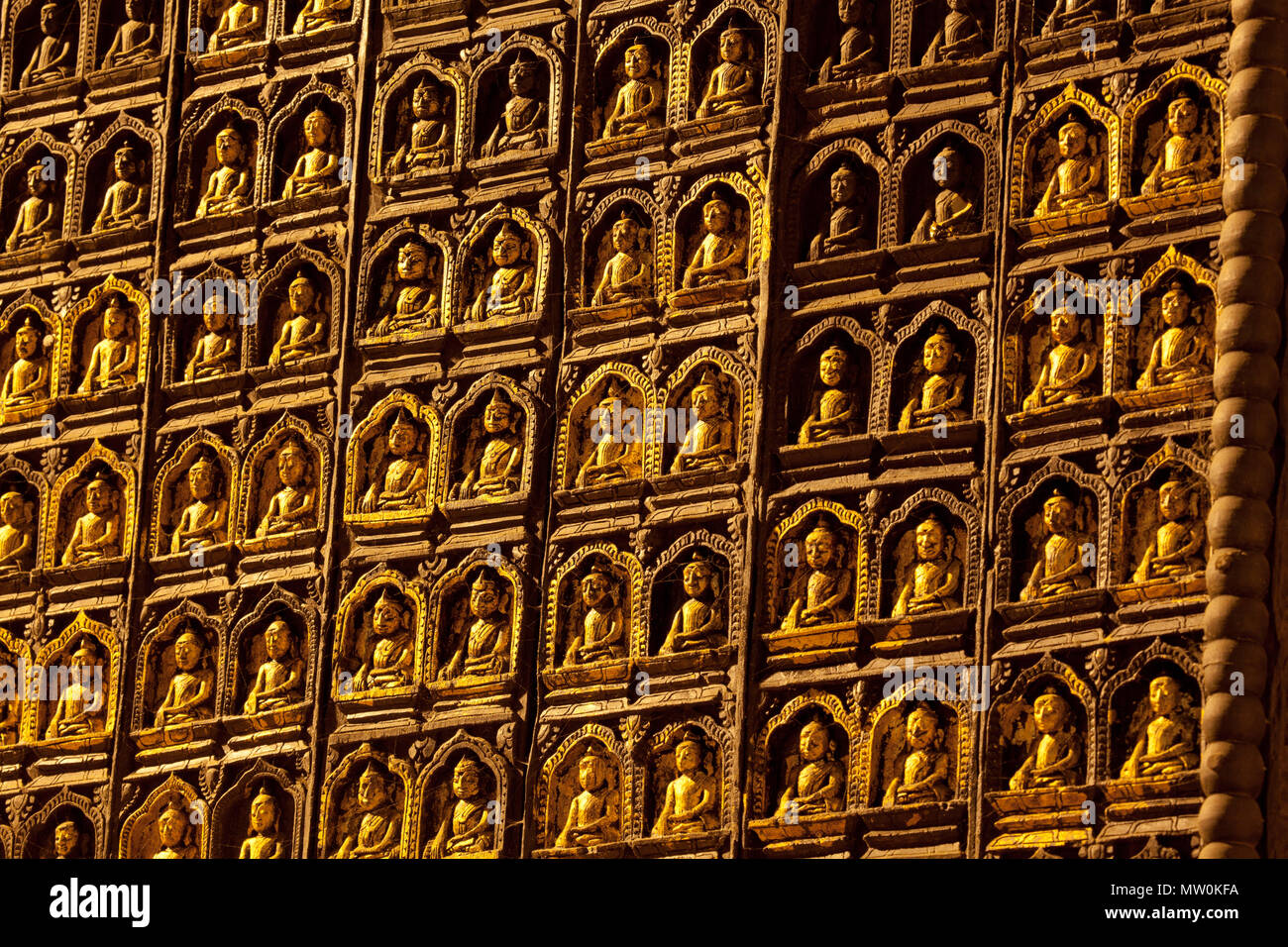 Piccolo Buddha immagini sul lato di un massiccio obelisco in grotte di pietra calcarea di Pindaya, Birmania. Foto Stock