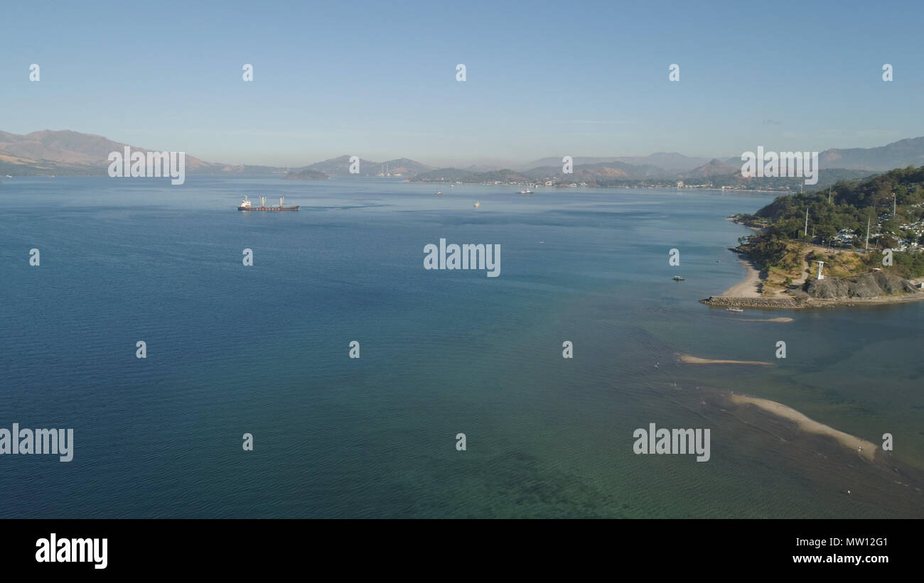 Baia Mare con navi da carico sullo sfondo delle montagne. Veduta aerea del porto di mare. Subic Bay, Filippine, Luzon. Foto Stock