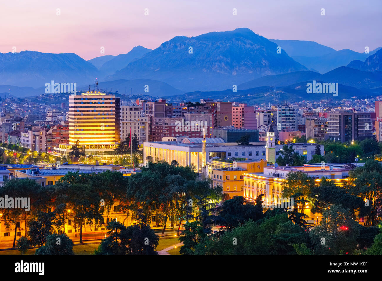 Vista della città e dal centro città con il Palazzo della Cultura, Ethem-Bey moschea e la Torre dell Orologio, montagne nel retro, crepuscolo, Tirana Foto Stock
