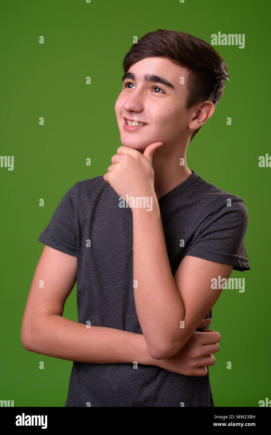 Giovani iraniani bello ragazzo adolescente contro lo sfondo di colore verde Foto Stock