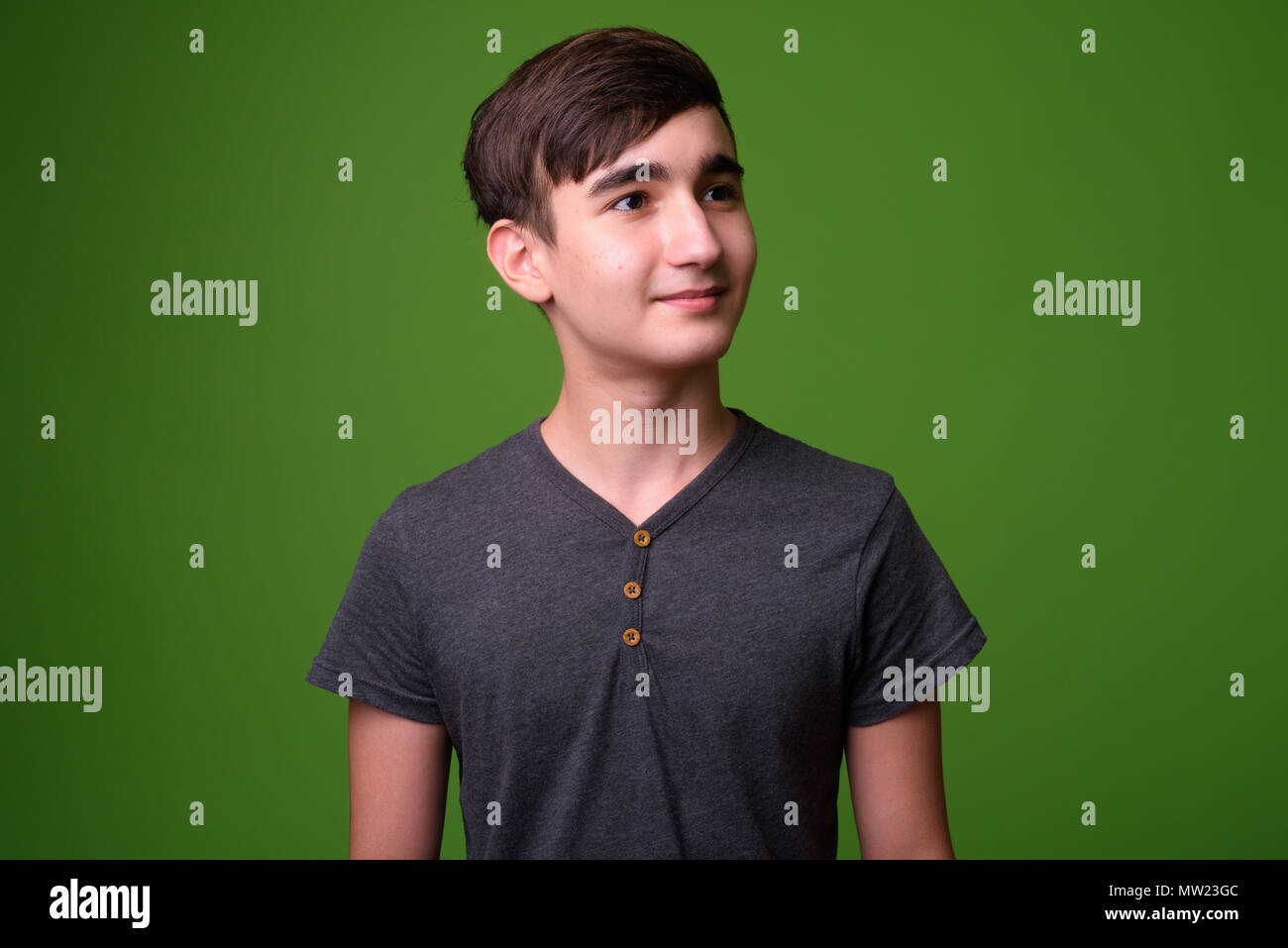 Giovani iraniani bello ragazzo adolescente contro lo sfondo di colore verde Foto Stock