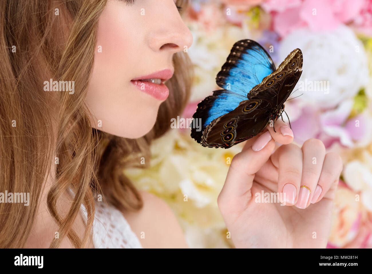 Ritagliato colpo di giovane donna con farfalla a portata di mano Foto Stock