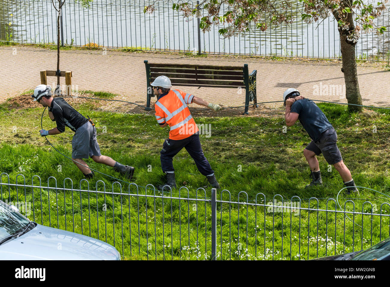 A sud ovest di lavoratori di elettricità tira un cavo in posizione. Foto Stock