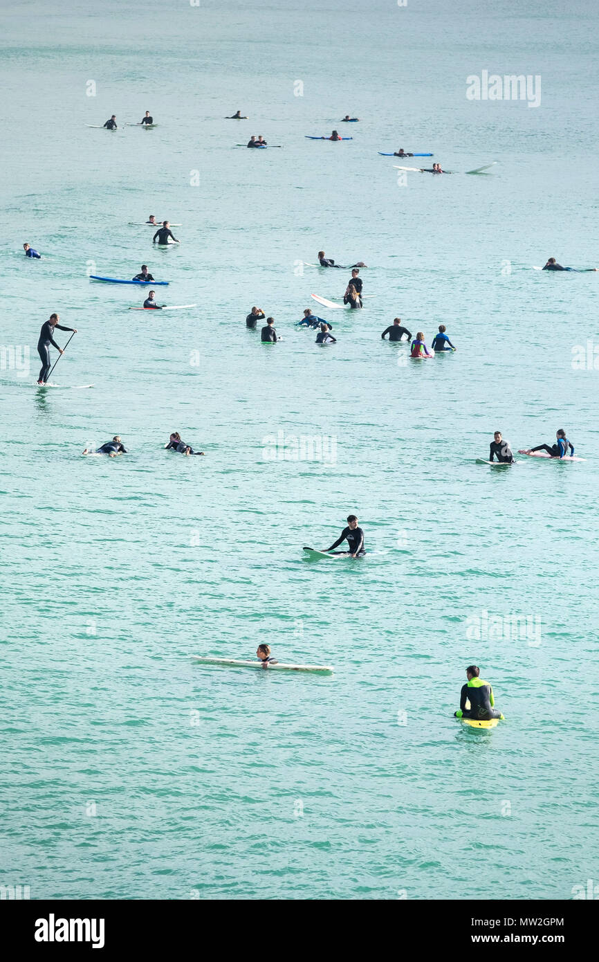 Surfers in attesa di un onda in un mare calmo a Fistral a Newquay in Cornovaglia. Foto Stock