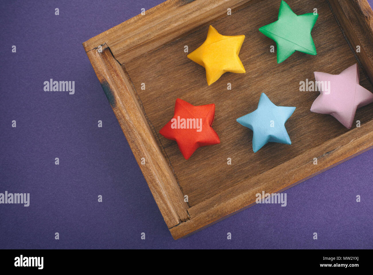 Origami colorati lucky stelle in una scatola di legno. Close up. Foto Stock