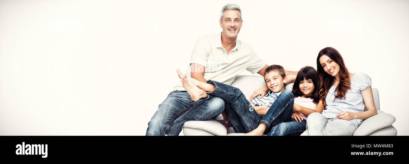 Famiglia seduti sul divano sorridente in telecamera Foto Stock