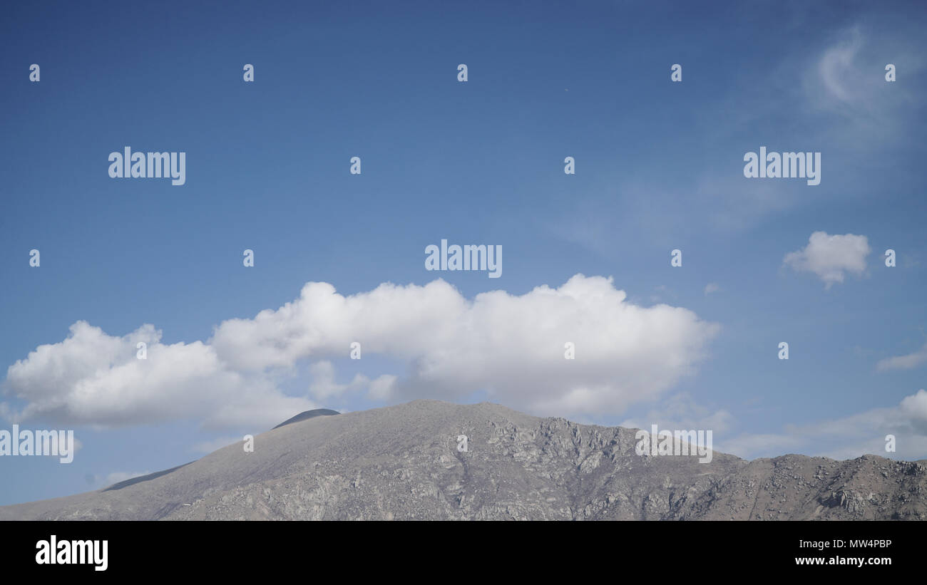 Montagna con qualche nuvola sul blu cielo chiaro Foto Stock