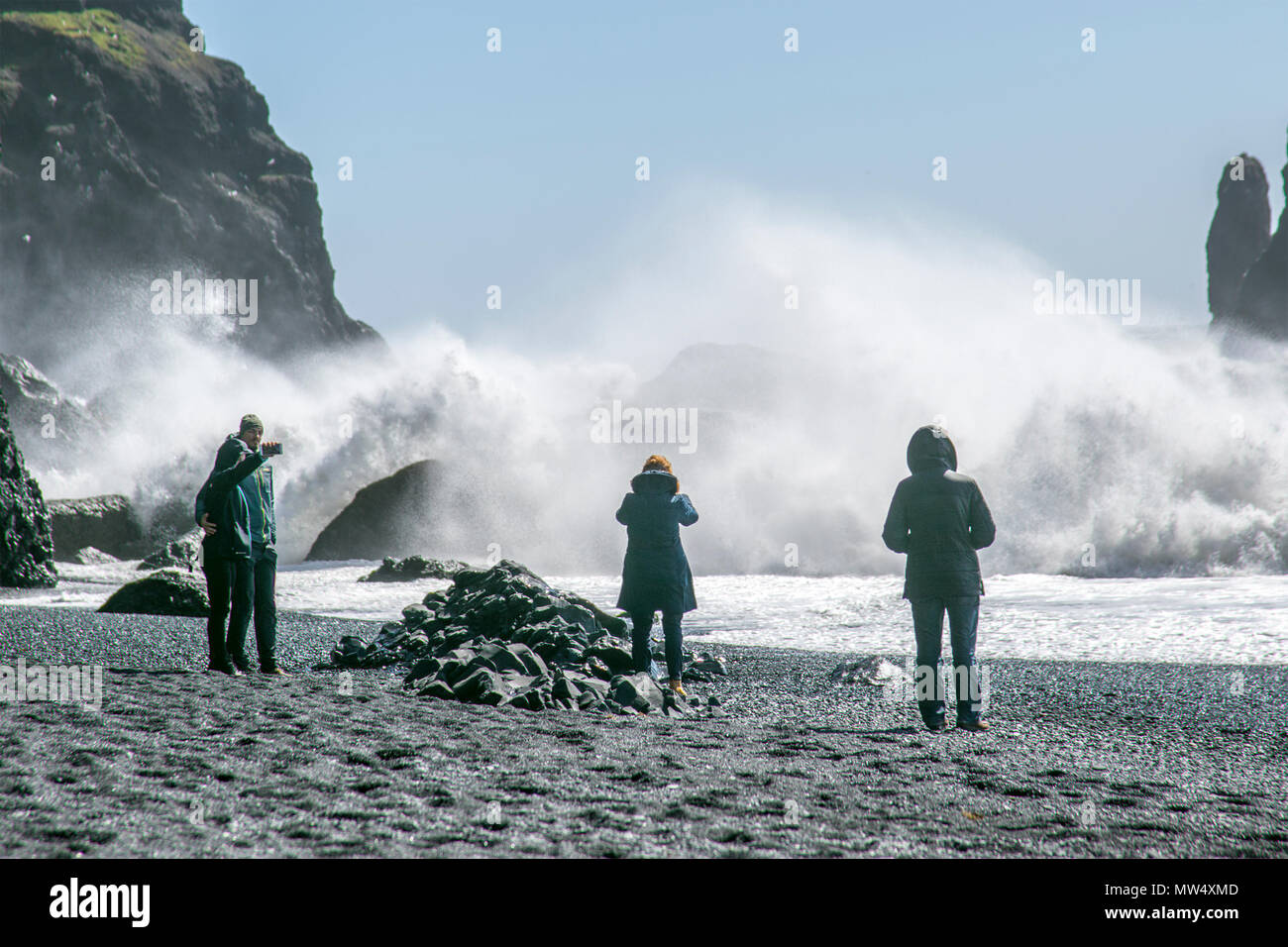Vík í Mýrdal beach; Reynisfjara Beach dispone di ciottoli neri, famosa in tutto il mondo con sabbia nera, colonne di basalto e il Reynisdrangar offshore formazioni di roccia. Un remoto villaggio sul mare dove la spiaggia è anche noto per pericolosamente grandi onde sneaker. Spiaggia di Reynisfjara, tuttavia, può essere un posto pericoloso in caso di maltempo e turisti che avventurarsi troppo vicino all'acqua può essere improvvisamente spazzate fuori i loro piedi da una potente onda. Foto Stock