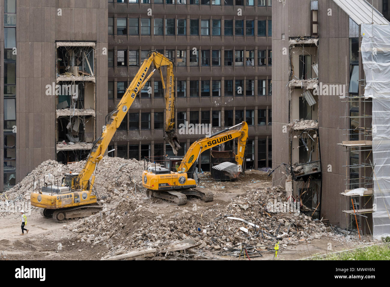 Vista alta del sito di demolizione con macerie, macchinari pesanti (escavatori) che lavorano e demoliscono edifici di uffici vuoti - Hudson House, York, Inghilterra, Regno Unito. Foto Stock