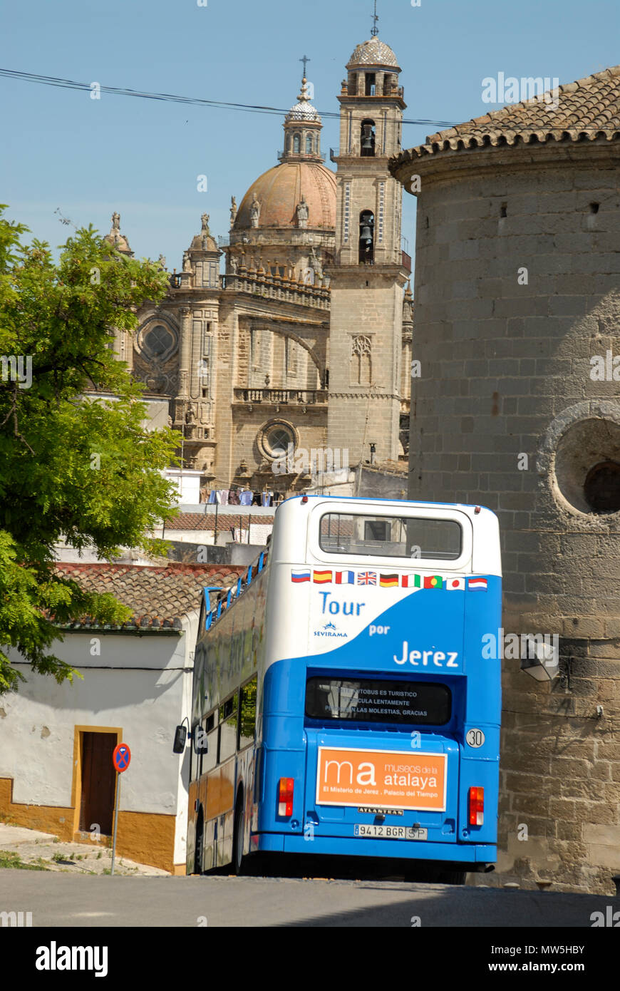 Un turista double-decker bus scende per una stradina nel centro storico di Jerez de la Frontera in Andalusia, sud della Spagna. In fondo è il Foto Stock