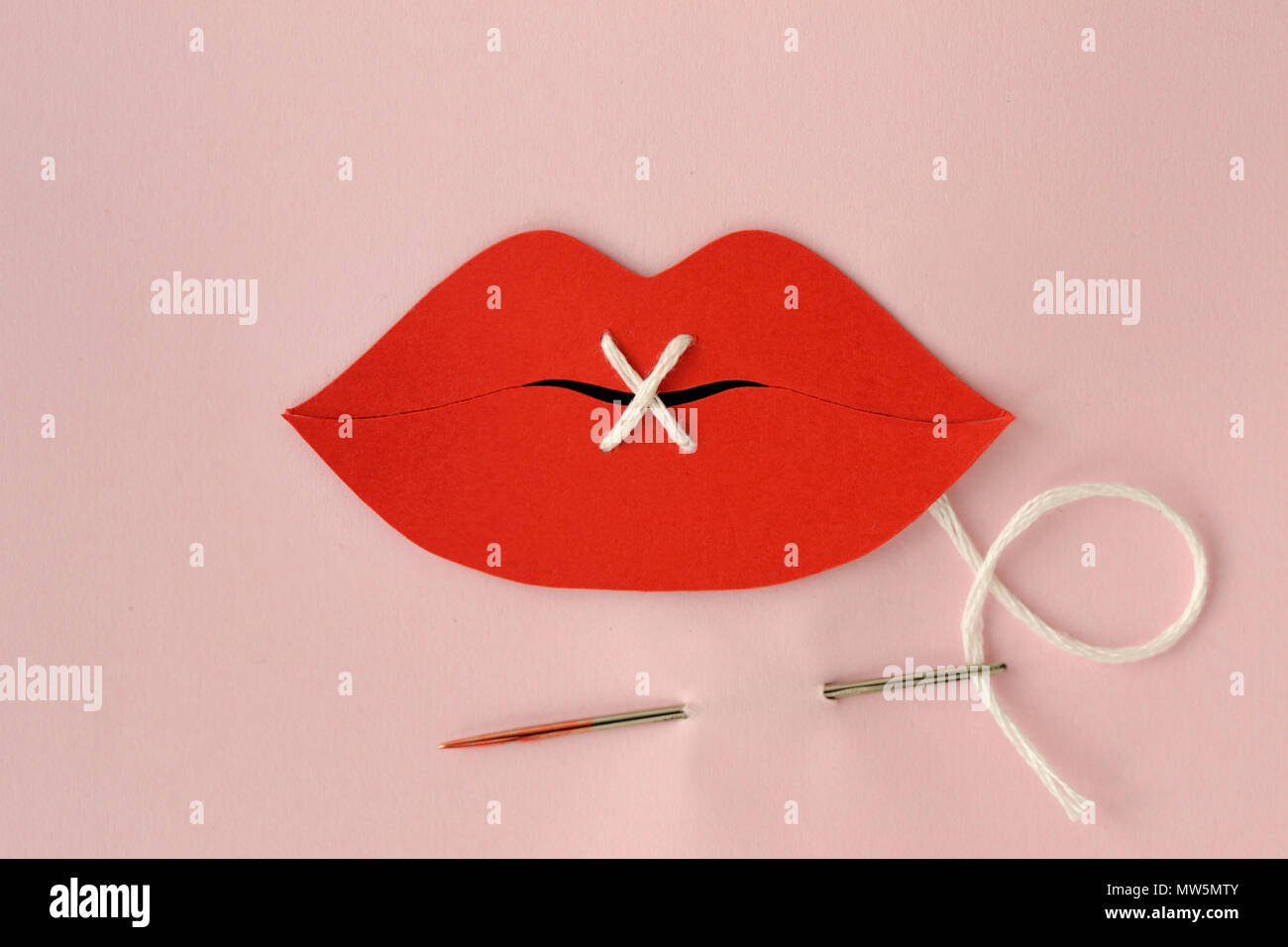 Le labbra di carta ritagliata cuciti con filo bianco - La violenza contro le donne concept Foto Stock