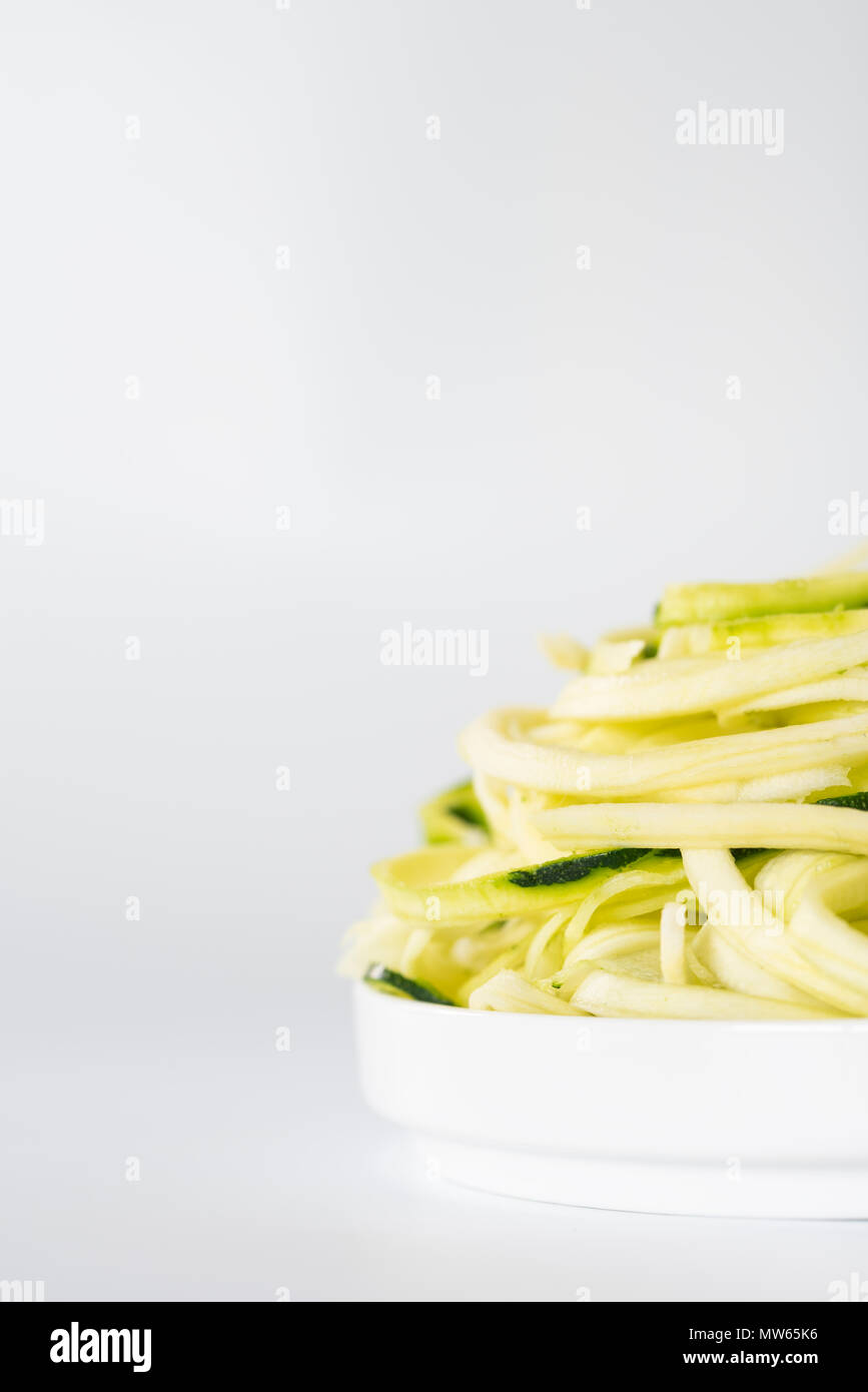 Zucchine Spiralised contro uno sfondo bianco con spazio per la copia. Foto Stock