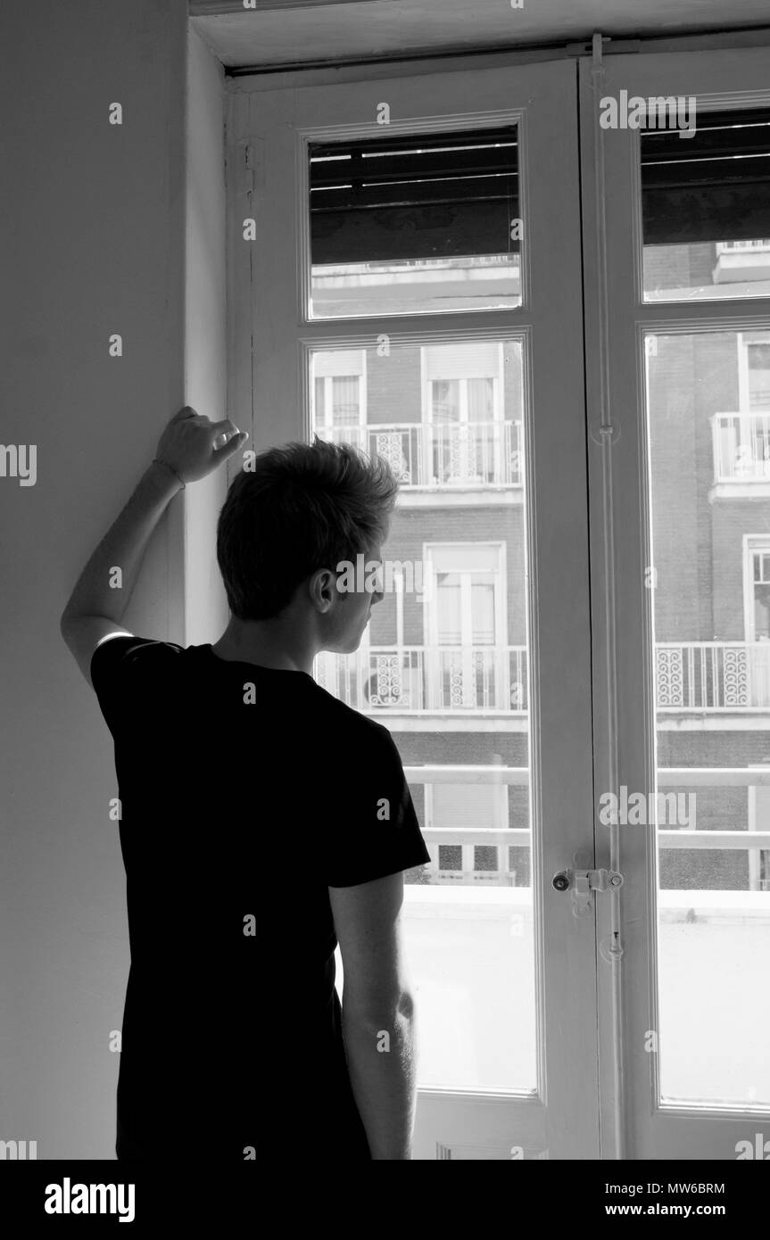 Giovane uomo dalla finestra. In bianco e nero Foto stock - Alamy