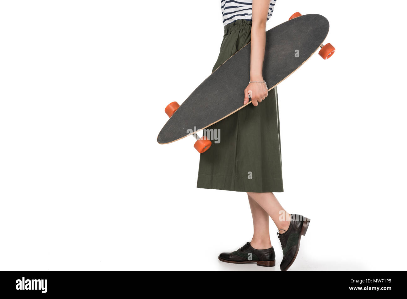 Ritagliato colpo di tanga elegante ragazza nel mantello di contenimento isolato di skateboard su bianco Foto Stock