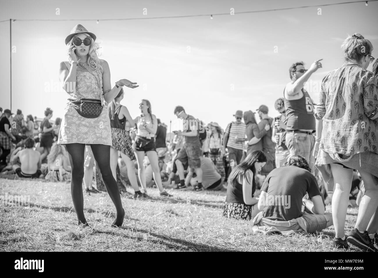 Un festival goer parla sul suo telefono presso il festival di Glastonbury 2015 Foto Stock