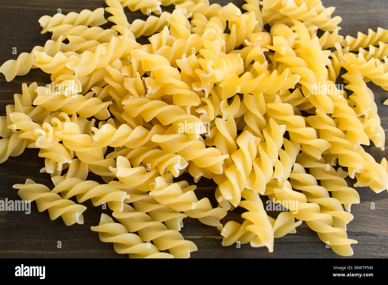 La pasta italiana I fusilli su uno sfondo di legno. Foto Stock