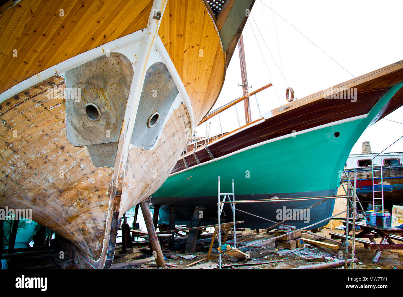 Cantiere navale contenente due navi in legno per la riparazione e il rinnovo di lavori di verniciatura a scafi, Cipro settentrionale. Foto Stock