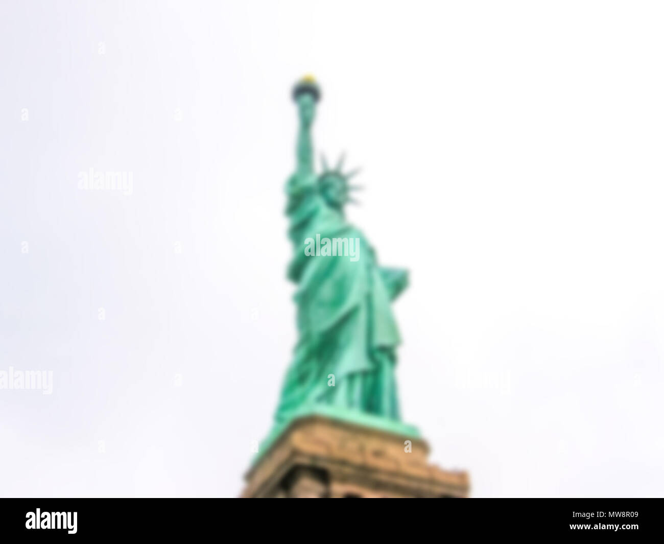 Sfondo sfocato con Statua della Libertà con cielo nuvoloso, New York City, Stati Uniti. Intenzionalmente sfocate di post produzione per effetto bokeh di fondo Foto Stock