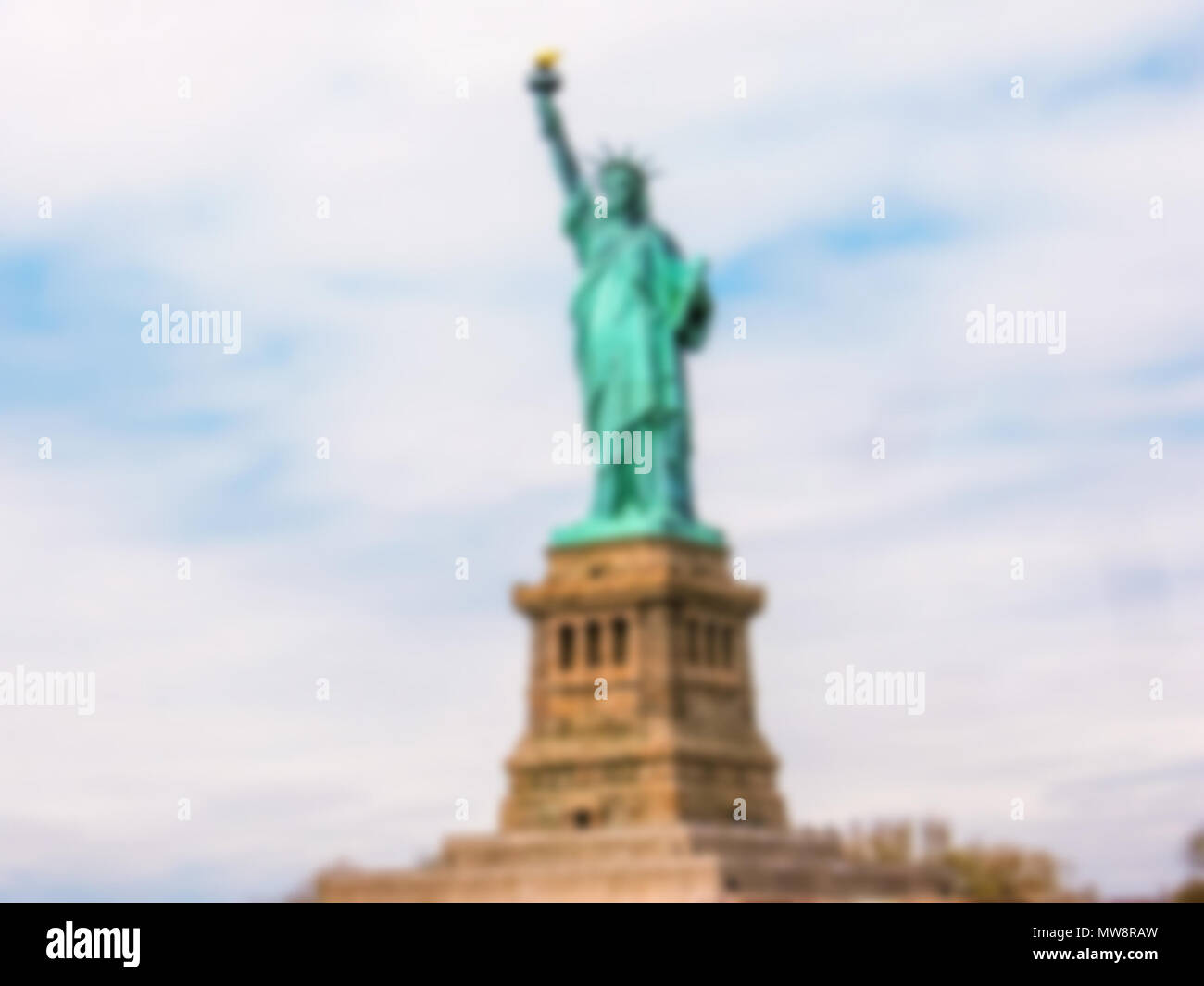 Sfondo sfocato con Statua della Libertà con cielo nuvoloso, New York City, Stati Uniti. Intenzionalmente sfocate di post produzione per effetto bokeh di fondo Foto Stock