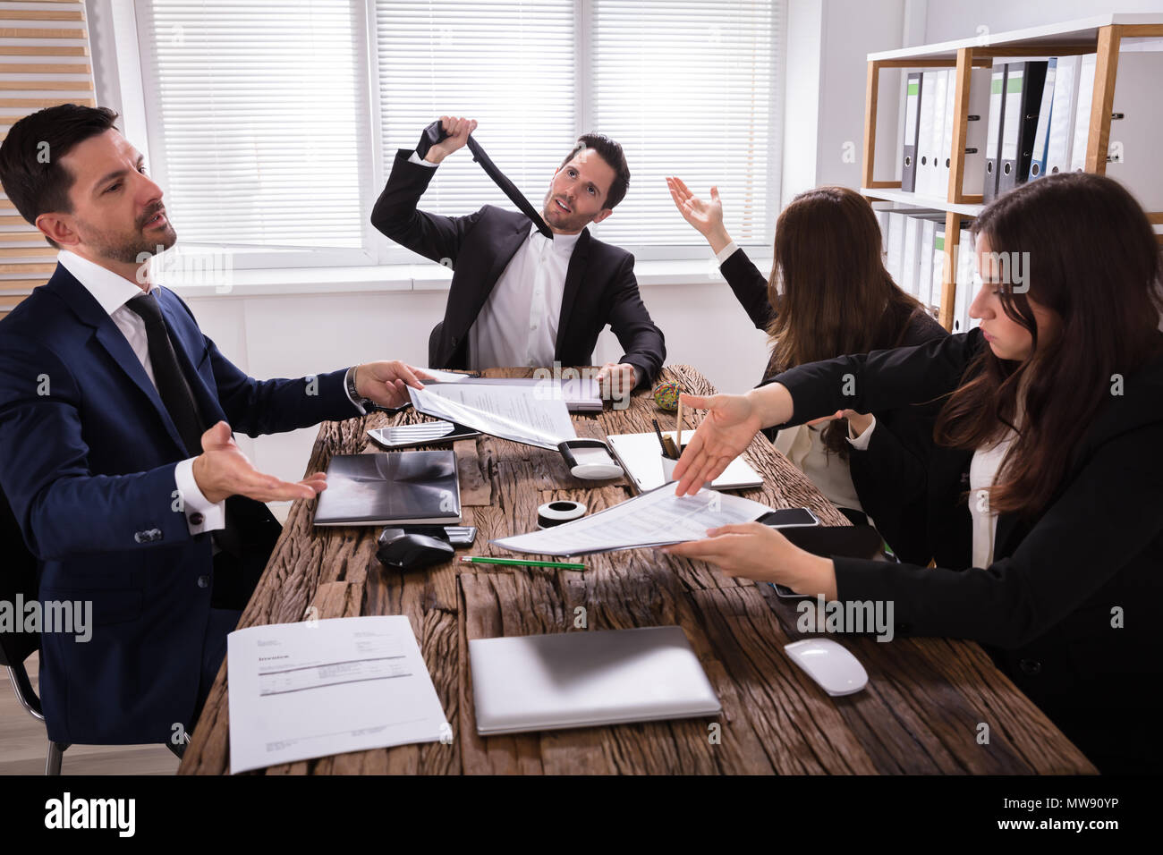 Gruppo di frustrati i giovani imprenditori avendo discussioni in riunione Foto Stock