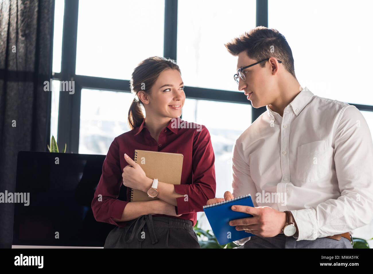 Giovane e bella direttrice flirtare con la sua collega, ufficio concetto romantico Foto Stock