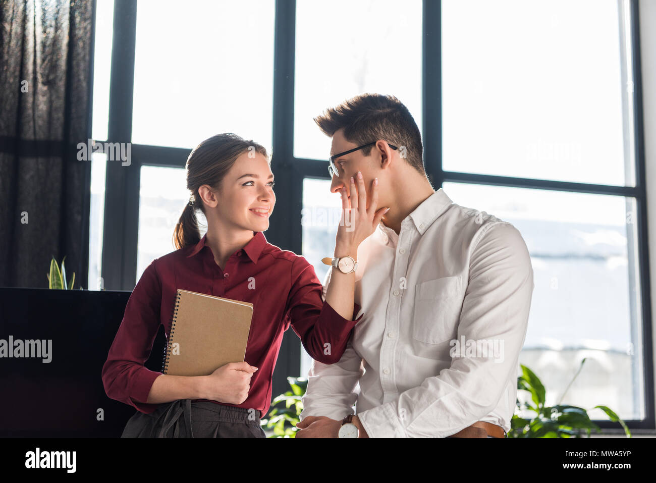 Giovani direttrice flirtare con la sua collega, ufficio concetto romantico Foto Stock