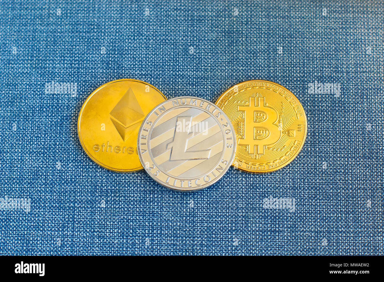 Crypto valuta Moneta Bitcoin, Litecoin Ethereum e monete in portafoglio in pelle su sfondo blu. Foto Stock