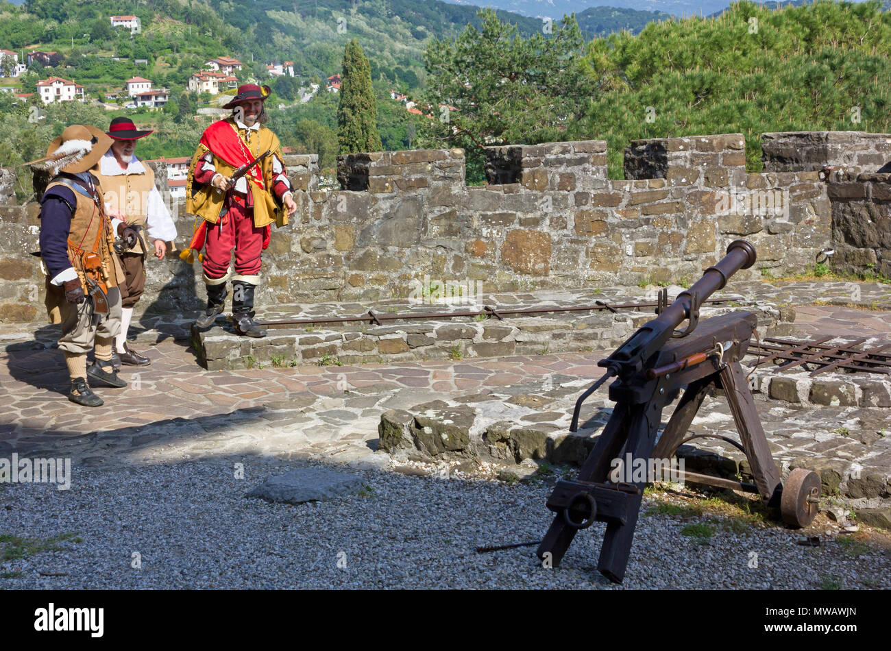 GORIZIA, Italia - 6 Maggio 2018: Diciassettesimo secolo cannone e tre uomini in costume alla rievocazione storica tenuta al castello Foto Stock