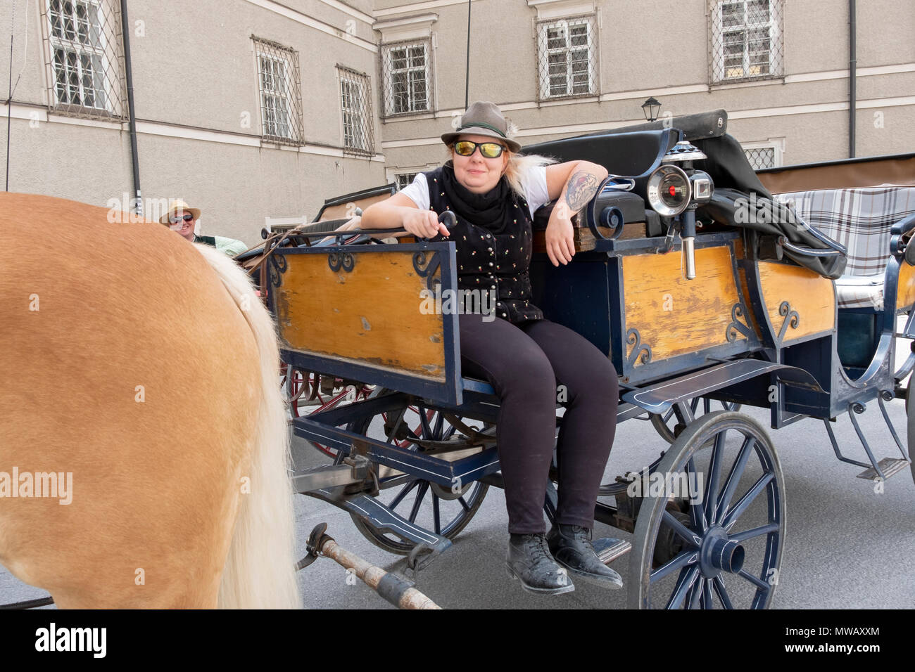 Un operaio la pulizia dell'area dai giri in carrozza per i turisti a Salisburgo, Austria. Foto Stock