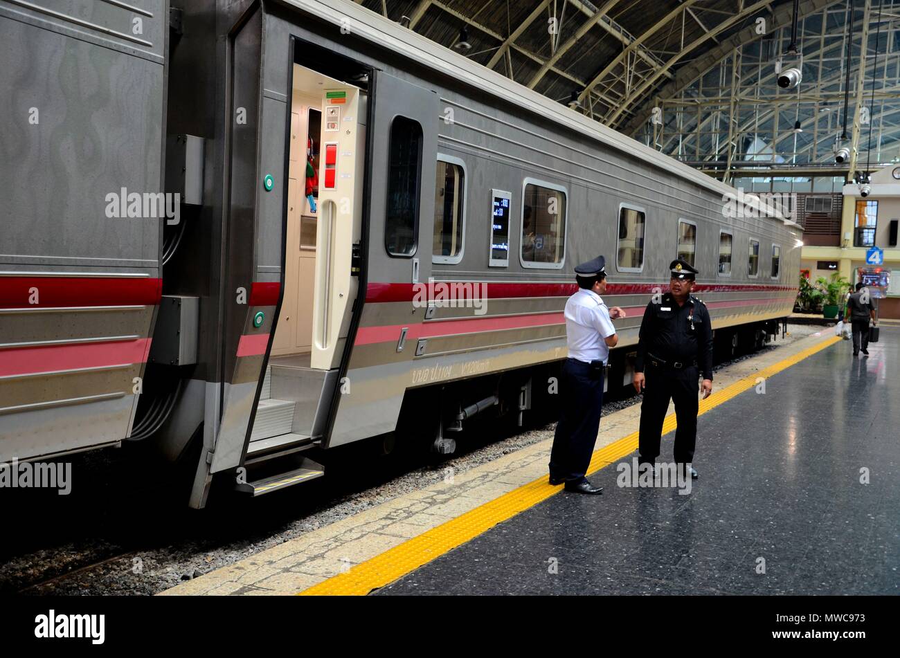 Ferrovie tailandese per tutta la notte la traversina treni passeggeri e trasporto in sosta in corrispondenza della stazione della piattaforma con uniformata lavoratori ferroviari Hua Lamphong Bangkok in Thailandia Foto Stock