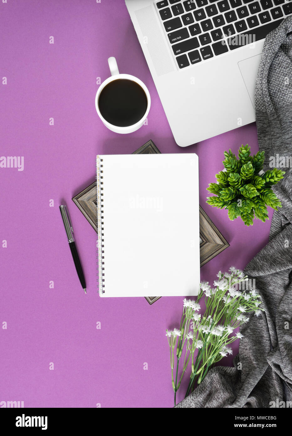 Home spazio lavoro con notebook, laptop e caffè sul pastello sfondo violetto. Home ufficio laici piatta vista dall'alto. Foto Stock