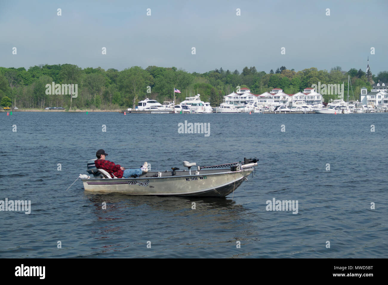 Uomo di pesca sul lago bianco durante la tarda primavera a metà mattina. Foto Stock