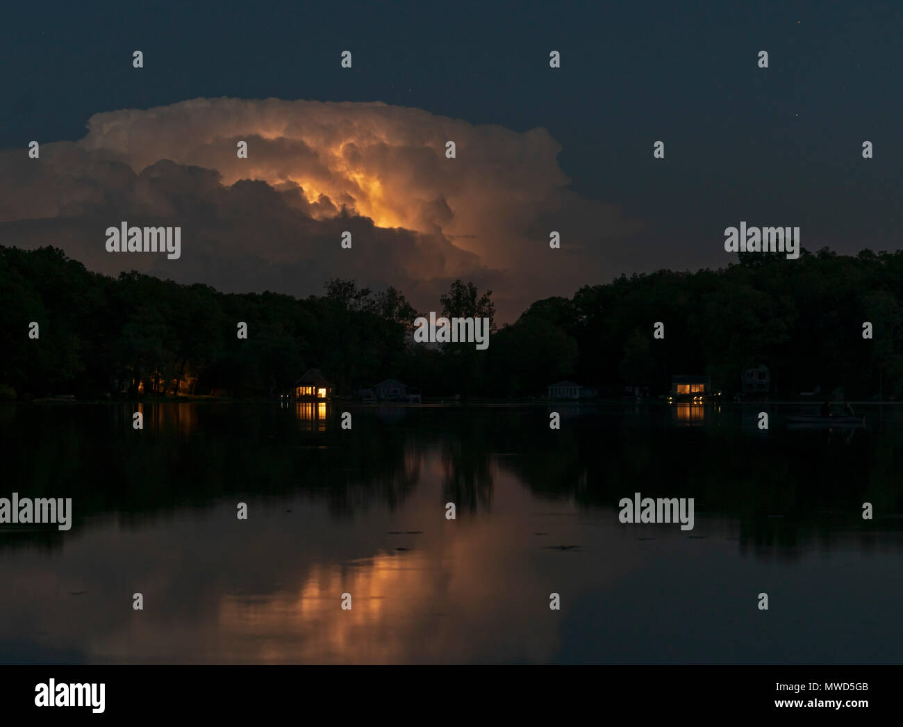 Prairieville, Michigan - fulmini da una lontana tempesta si riflette nelle acque del lago Stewart. Foto Stock