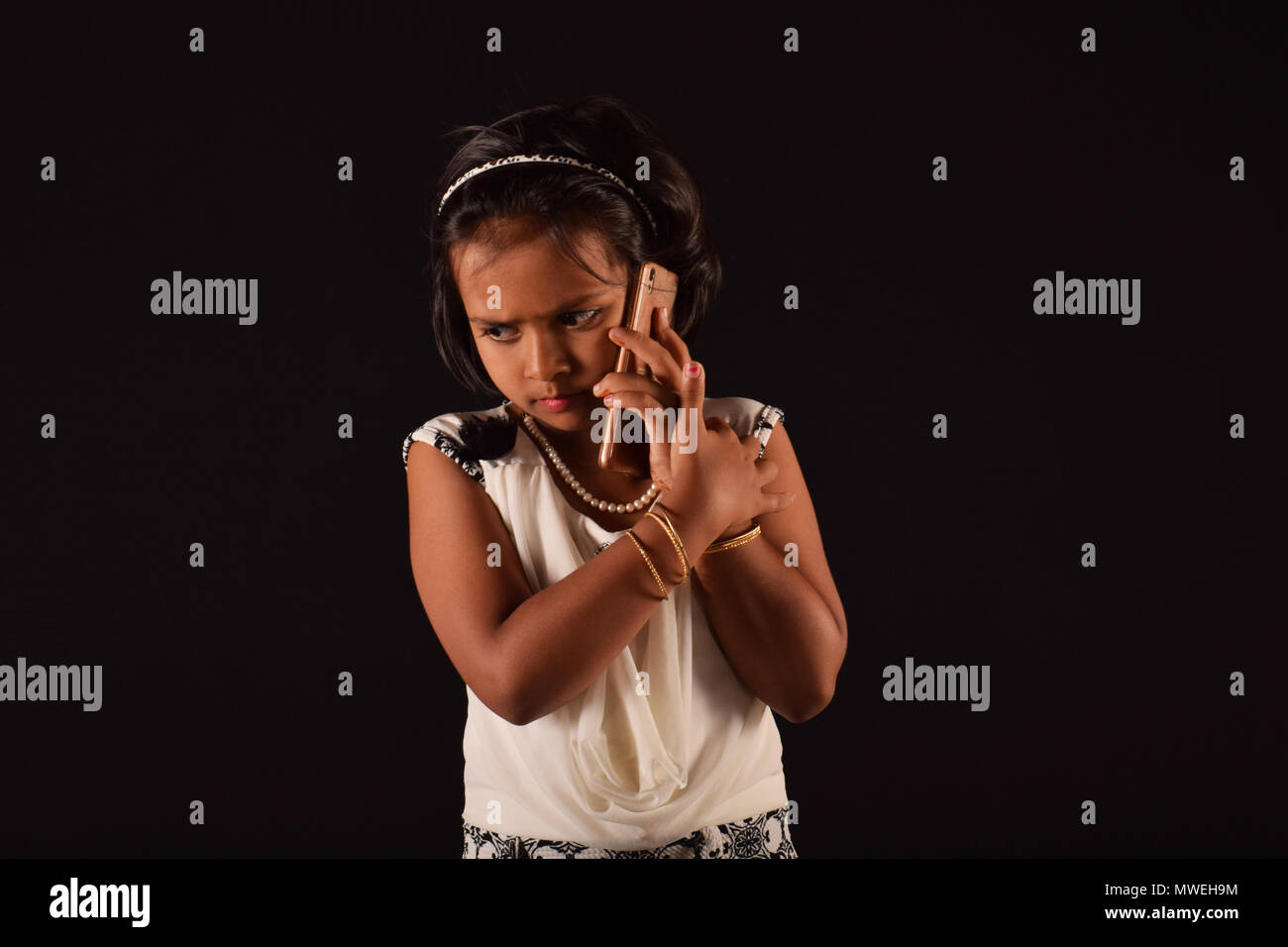 Bambina per parlare a qualcuno sul telefono cellulare, Pune Foto Stock