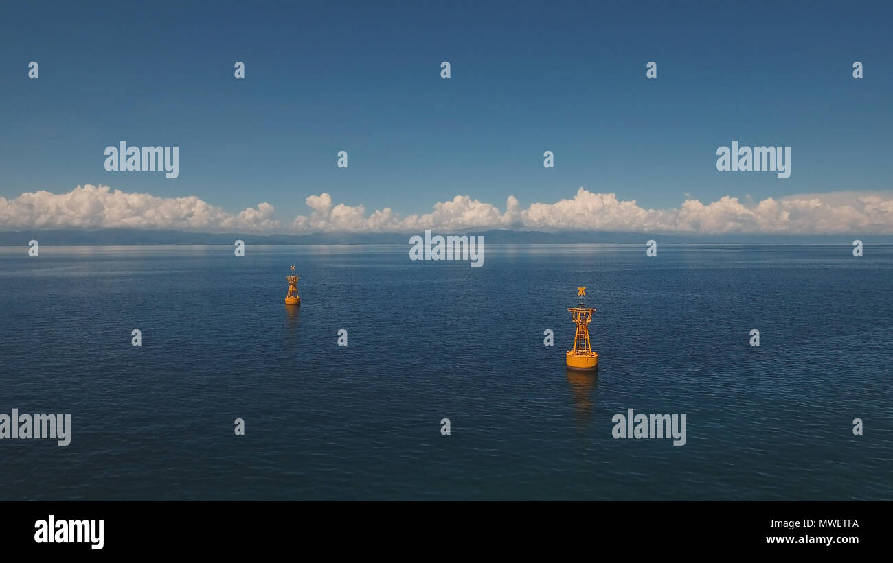 Boa arancione nel mare blu su uno sfondo di cielo blu e nuvole, isola. Vista aerea:boa di navigazione nell'oceano.Filippine, Cebu. Concetto di viaggio. Foto Stock