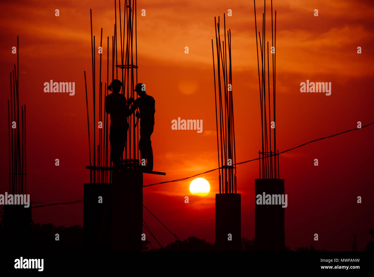 Persone che lavorano duramente con il tramonto del sole Foto Stock