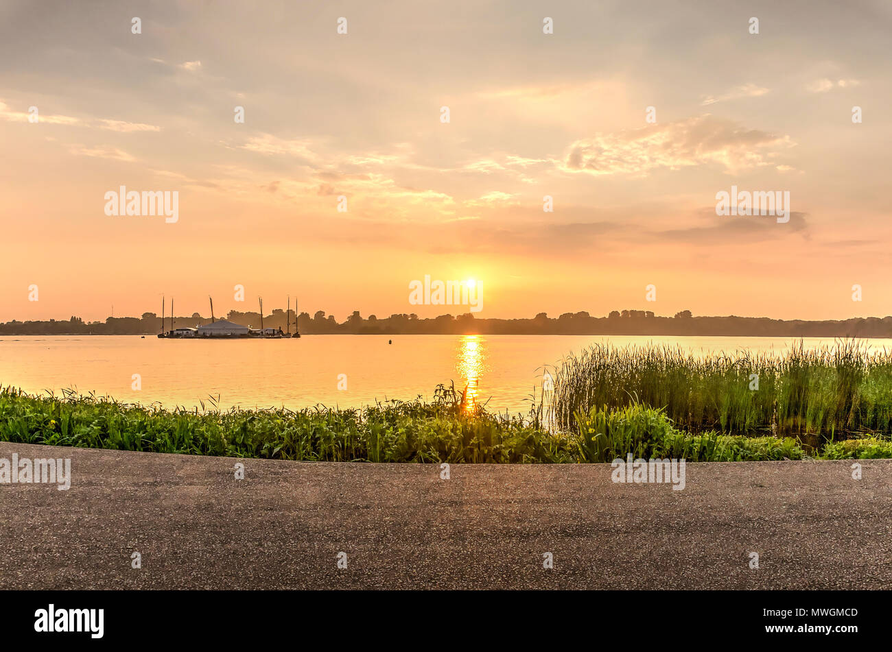 Tramonto sul lago Kralingse Plas in Rotterdam, i Paesi Bassi, come si vede dalla passeggiata sulla riva orientale Foto Stock