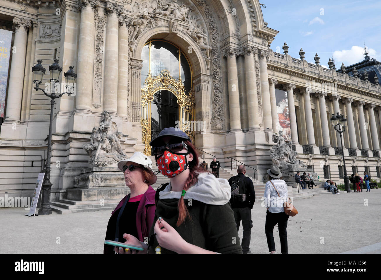 Una donna che indossa un anti inquinamento maschera respiratoria a piedi al di fuori del Petit Palais museo nelle strade di Parigi Francia KATHY DEWITT Foto Stock