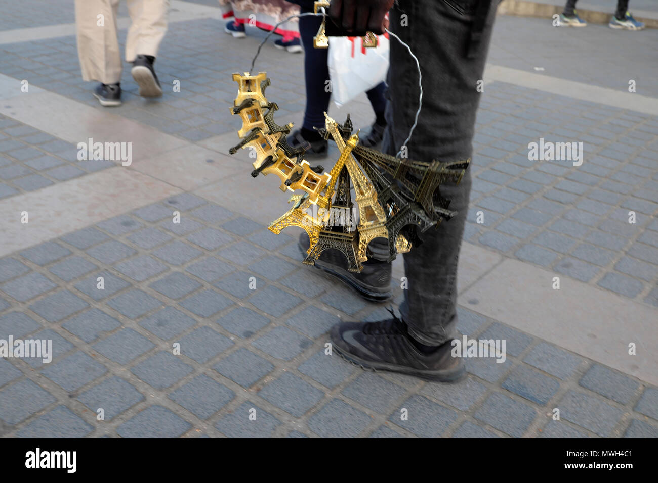 Street trader vendere oro in miniatura in plastica repliche turistica della Torre Eiffel Parigi, Francia KATHY DEWITT Foto Stock