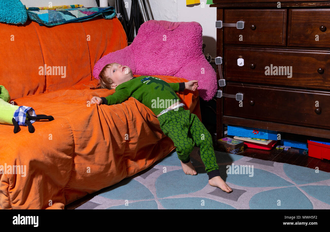 Toddler Caucaso giace sul suo lettino nella sua camera da letto prima di andare a letto Foto Stock