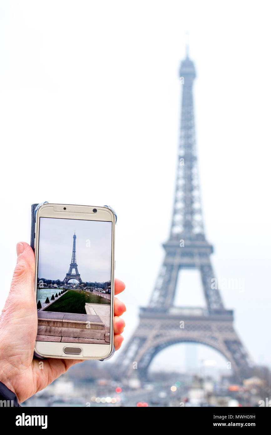 Donna di fotografare la Torre Eiffel con il suo smartphone, Parigi, Ile de France, Francia, Europa Foto Stock