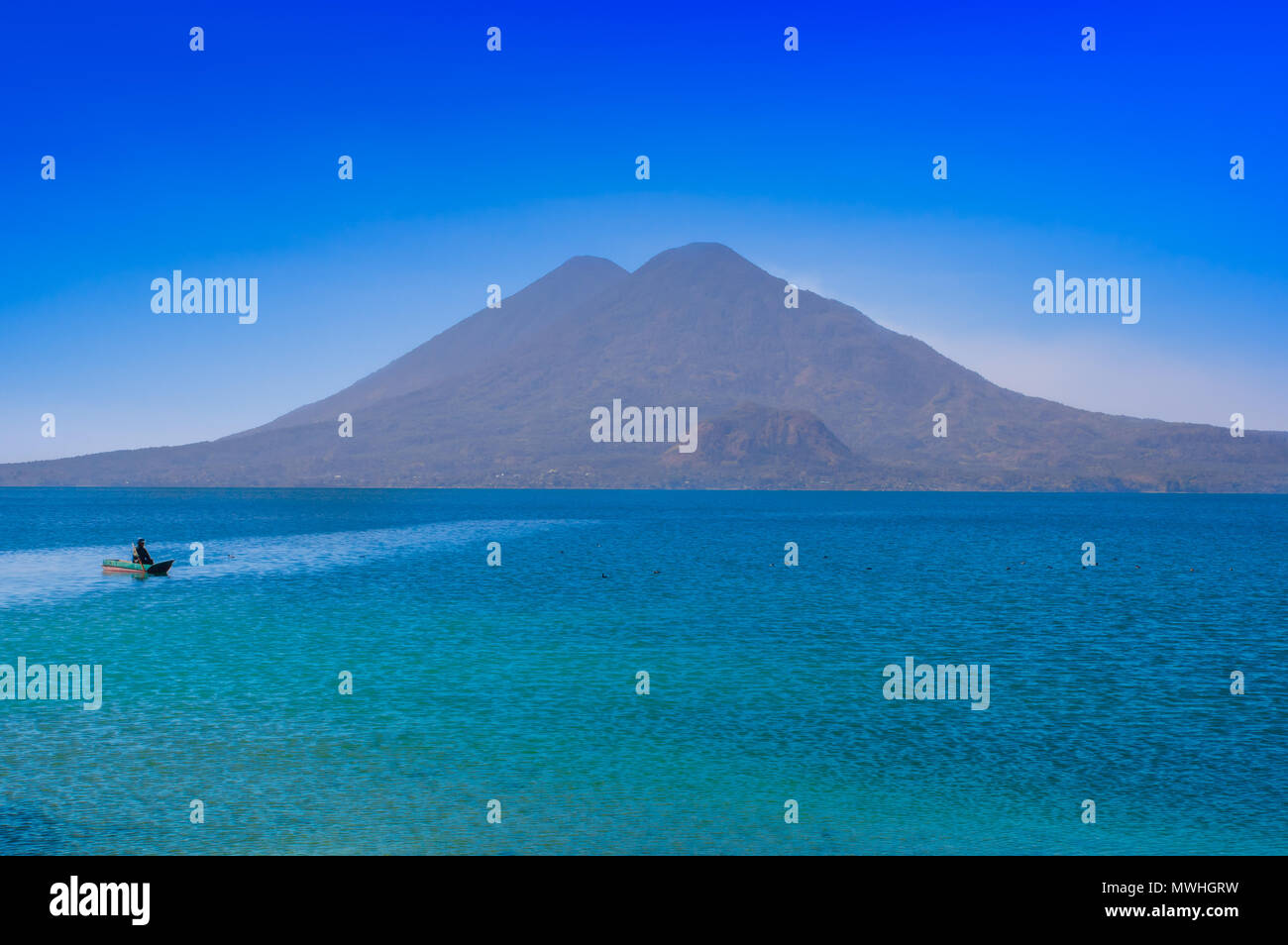 Bella vista esterna delle piccole barche nel lago Atitlan è il lago più profondo di tutto il Centro America con una profondità massima di circa 340 metri, con il vulcano in background in Guatemala Foto Stock
