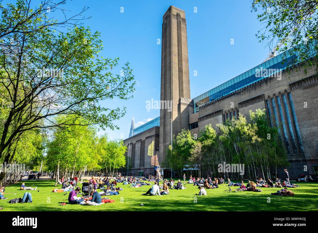 Vista di persone sull'erba al di fuori della Tate Modern Museum sulla Southbank, London, England, Regno Unito Foto Stock