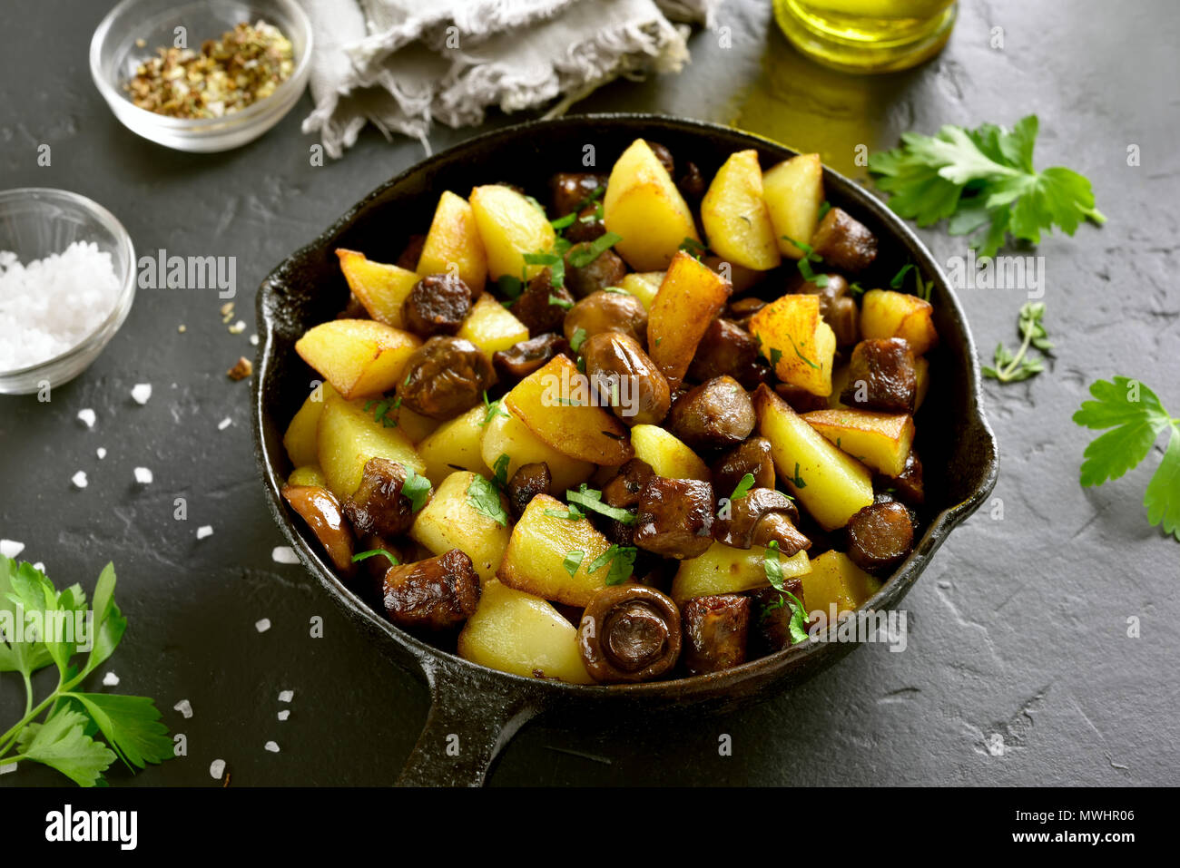 Patate Fritte Con Funghi E Salsiccia In Padella Nera Sul Tavolo Di Pietra Foto Stock Alamy