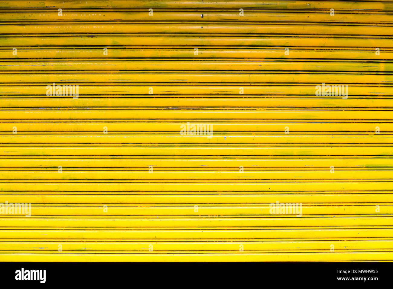 Rullo di metallo verniciato in vivace sfondo giallo Foto Stock