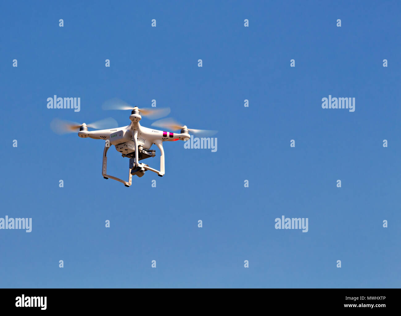 Un Drone in volo contro un cielo blu chiaro con abbondanza di spazio di copia Foto Stock