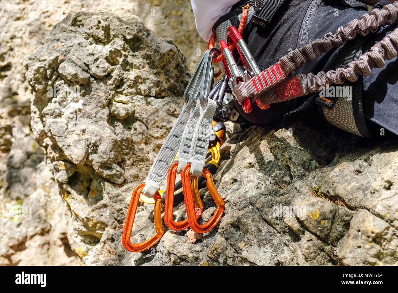 Uomo con ingranaggio di arrampicata e apparecchiature su una roccia Foto Stock